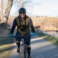 Biking with a DSLR in the My Fave Camera Harness with the Chest Strap securing the lens upright.